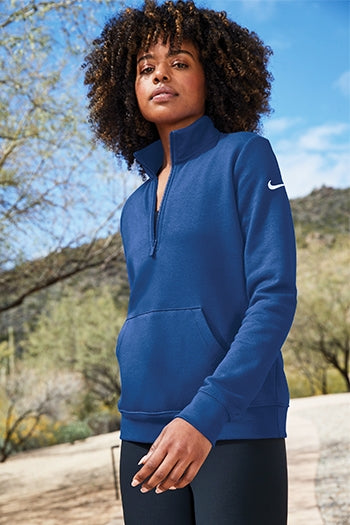 A shot of a woman wearing Nike Women's Club Fleece Sleeve Swoosh 1/2-Zip.