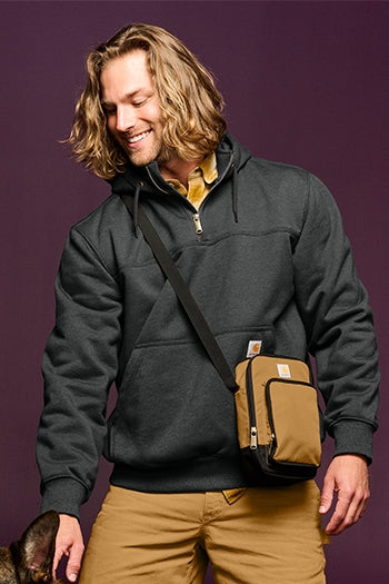 A shot of a man wearing Carhartt  Rain Defender Paxton Heavyweight Hooded Zip Mock Sweatshirt.