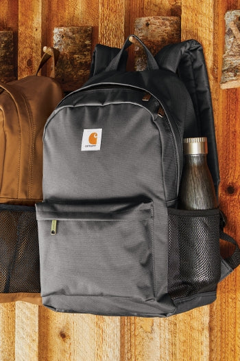 A grey Carhartt® Canvas Backpack hanging on a wall.