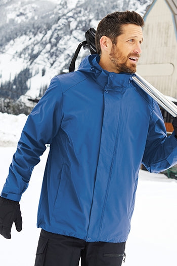 A shot of a man wearing Port Authority All-Weather 3-in-1 Jacket at a skiing resort.