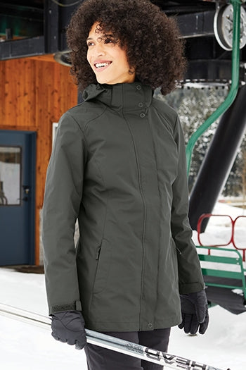 A shot of a woman wearing Port Authority Women's All-Weather 3-in-1 Jacket at a ski resort.