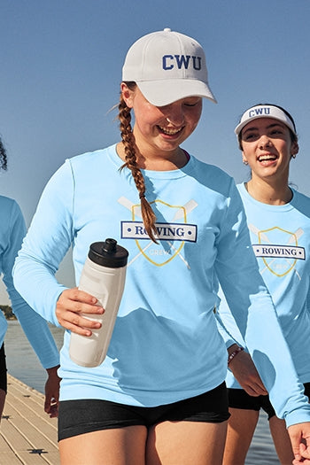 A shot of a woman in Sport-Tek® Women's Posi-UV® Pro Long Sleeve at a track field.