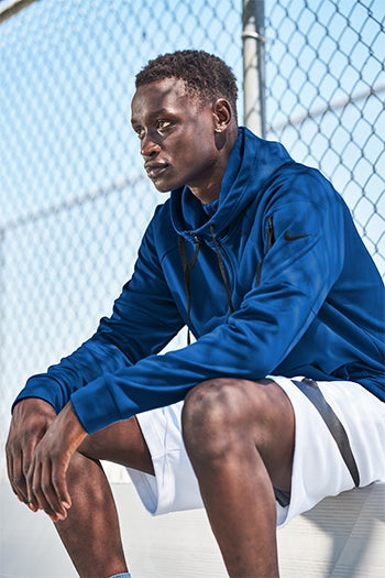 A shot of a man wearing Nike Therma-FIT Pocket 1/4-Zip Fleece Hoodie.