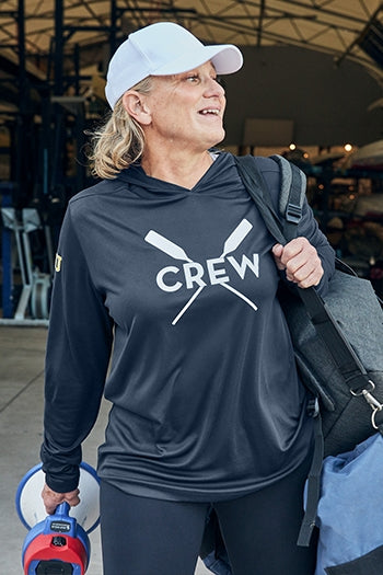 A shot of a woman wearing Sport-Tek® Posi-UV® Pro Long Sleeve Hoodie.